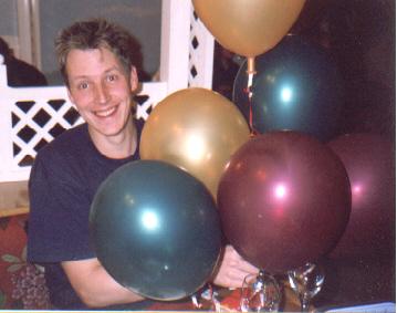 Picture of Neil with half a dozen brightly coloured and shiny balloons Picture of Neil with half a dozen brightly coloured and shiny balloons